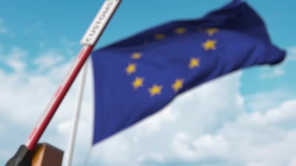 Barriärgrinden med tullskylten stängd med EU:s flagga som bakgrund. Stängning av europeiska gränser eller skyddstariffer — Stockvideo