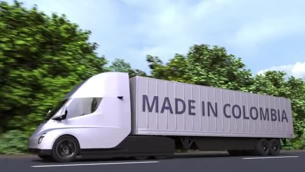 Camion semi-remorque électrique moderne avec texte MADE IN COLOMBIA sur le côté. Animation 3D bouclable liée à l'importation ou l'exportation colombienne — Video