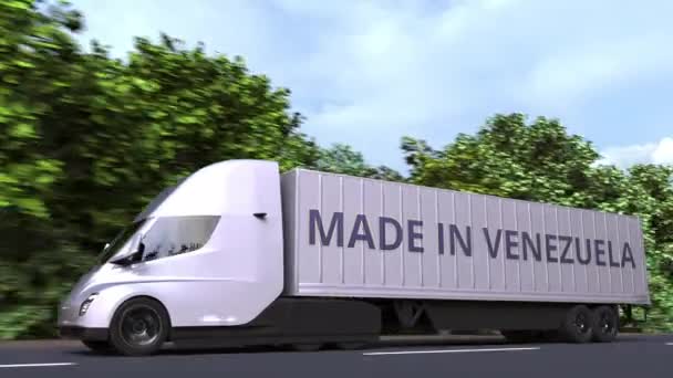 Moderno camión semirremolque eléctrico con texto MADE IN VENEZUELA en el lateral. Animación 3D loopable relacionada con la importación o exportación venezolana — Vídeo de stock