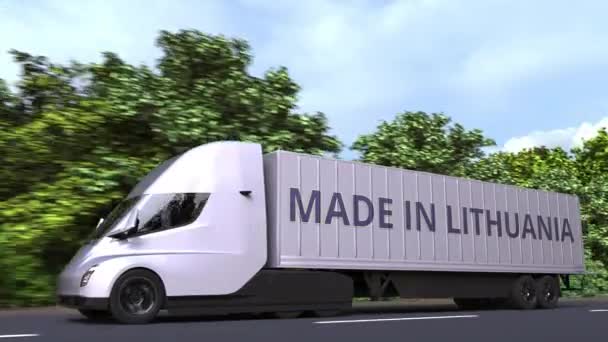 Сучасна електрична напівпричепна вантажівка з текстом "Made In Lithuania" збоку. Литовський імпорт або експорт Loopable 3d анімації — стокове відео