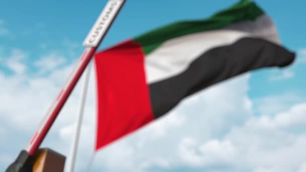 Cerrando la barrera del boom con el cartel de ADUANAS contra la bandera de los EAU. Cruce fronterizo restringido o tarifas de protección — Vídeos de Stock