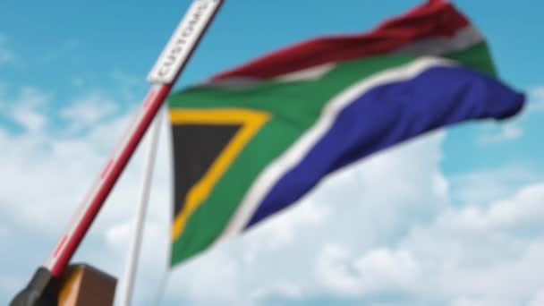 Cancello barriera con il segno DOGANALE di essere chiuso con la bandiera del Sud Africa come sfondo. Tariffe sudafricane limitate di attraversamento delle frontiere o di protezione — Video Stock