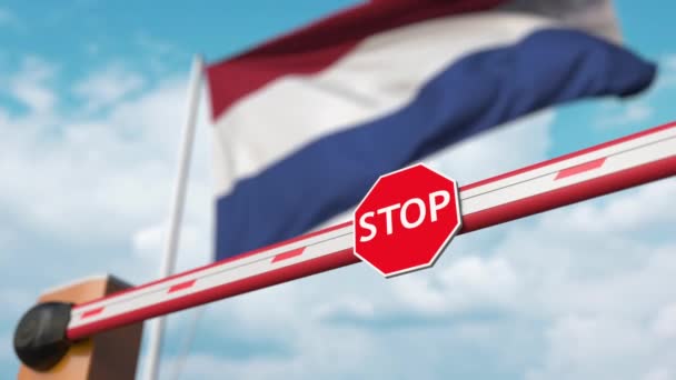 Barrera de apertura con señal de stop contra la bandera holandesa. Libre cruce de fronteras o levantamiento de una prohibición en los Países Bajos — Vídeos de Stock