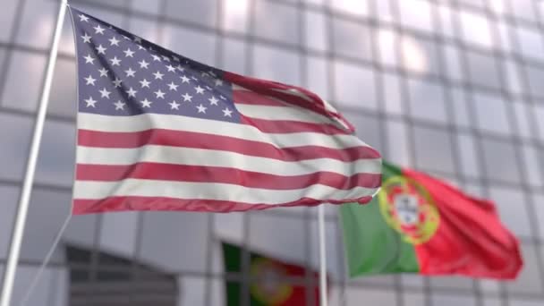 Drapeaux des États-Unis et du Portugal agitant devant une façade moderne de gratte-ciel — Video