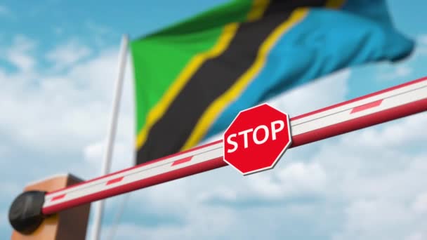 Öppnar bommbarriär med stoppskylt mot Tanzanias flagga. Fri gränspassage eller upphävande av förbud i Tanzania — Stockvideo