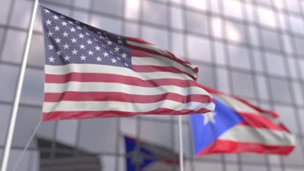 Waving flags of the United States and Puerto Rico in front of a modern skyscraper — Stock Video