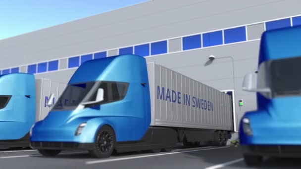 Camions remorques avec texte MADE IN SUEDEN en cours de chargement ou de déchargement en entrepôt. Suédois entreprise liée animation 3D bouclable — Video