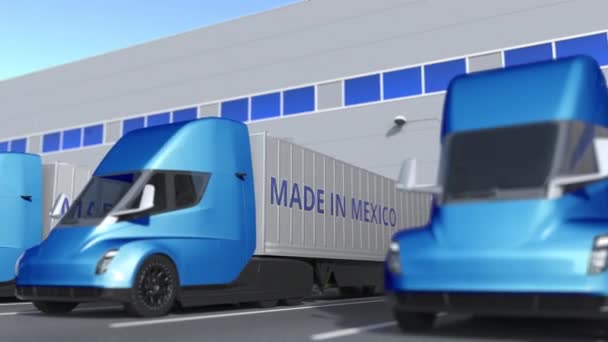 Modernos camiones semirremolques con texto MADE IN MEXICO siendo cargados o descargados en el almacén. Animación 3D loopable relacionada con negocios mexicanos — Vídeo de stock