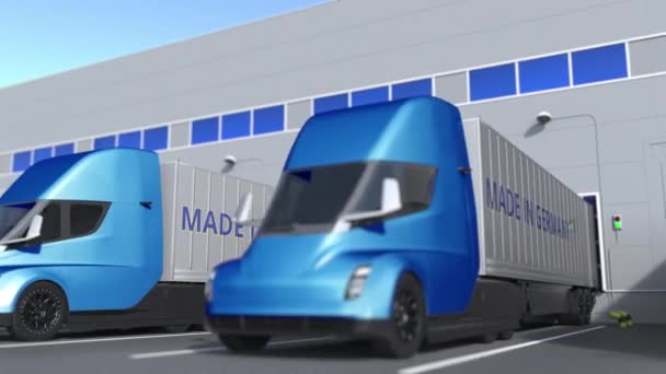 Camiones semirremolques modernos con texto MADE IN ALEMANIA que se cargan o descargan en el almacén. Animación 3D loopable relacionada con el negocio alemán — Vídeos de Stock