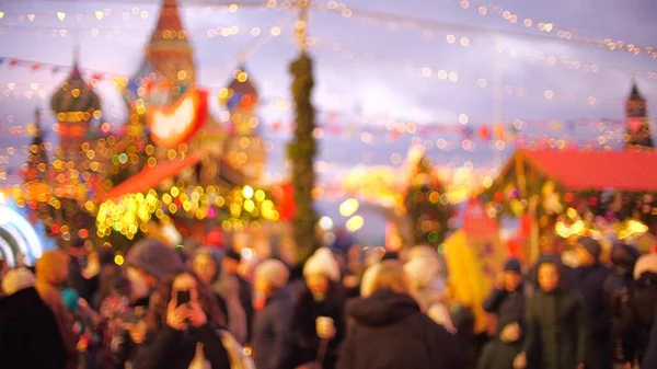 Niewyraźne osoby odwiedzające Nowy Rok i Świąteczny Bazar na Placu Czerwonym w pobliżu katedry św. Bazyliki w Moskwie, Rosja — Zdjęcie stockowe