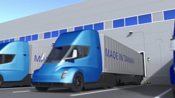 Camions semi-remorques modernes avec texte MADE IN TAIWAN chargé ou déchargé en entrepôt. Animation 3D bouclable liée aux affaires taïwanaises — Video