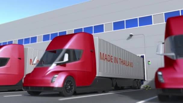 Made in Thailand yazılı modern yarı karavan kamyonları depoda yükleniyor ya da boşaltılıyor. Tayland iş ilişkili döngüsel 3D animasyon — Stok video