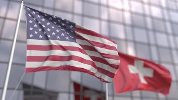 Waving flags of the United States and Switzerland in front of a modern skyscraper — Stock Video