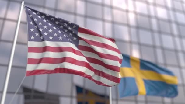 Machanie flagami Usa i Szwecji przed nowoczesnym drapaczem chmur — Wideo stockowe