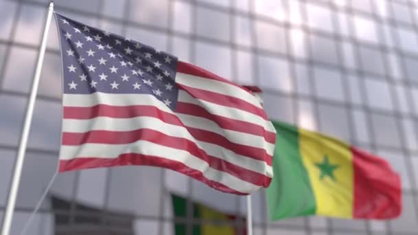 Az Egyesült Államok és Szenegál zászlóinak lobogtatása egy modern felhőkarcoló előtt — Stock videók