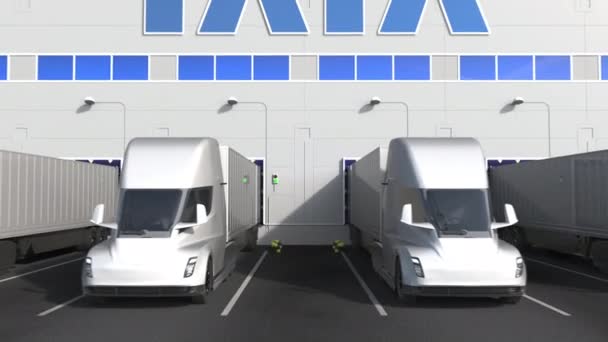 Depo yükleme bölümünde duvarında Tata logosu olan elektrikli yarı karavan kamyonları. 3d editör animasyonu — Stok video