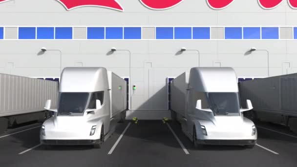 창고에 있는 전기 반 트레일러 트럭들 이 벽에 COCA-COLA 로고를 적재 하고 있습니다. 3D 애니메이션 편집기 — 비디오