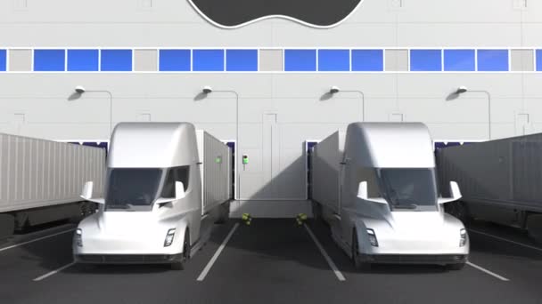 Depo yükleme bölümünde duvarında Apple Inc logosu olan elektirikli yarı karavan kamyonları. 3d editör animasyonu — Stok video