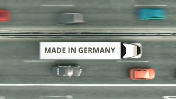 Воздушный обзор полуприцепов с текстом MADE IN GERMANY, движущимся по шоссе. Цифровая 3D анимация в Германии — стоковое видео