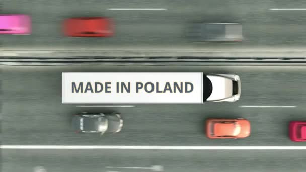 Widok z lotu ptaka przyczepy z tekstem Made In Poland jadącym wzdłuż drogi. Animacja 3D związana z polskim biznesem — Wideo stockowe