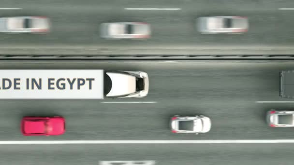Yolda giderken üzerinde Made in Egypt yazan yarı karavan kamyonlarının havadan aşağı görüntüsü. Mısır iş ilişkili döngüsel 3d animasyon — Stok video