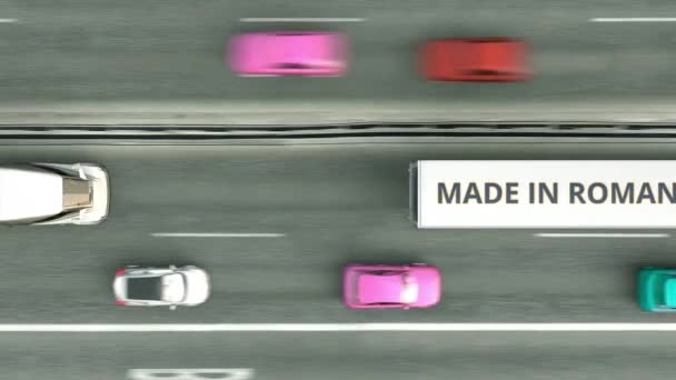 Bovenaanzicht vanuit de lucht van opleggertrucks met Made In Romania tekst die langs de weg rijdt. Roemeense business gerelateerde loopable 3d animatie — Stockvideo