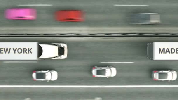 Vista aérea de cima para baixo de caminhões semi-reboque com texto MADE IN NEW YORK dirigindo ao longo da estrada. animação 3D loopable relacionada ao negócio — Vídeo de Stock
