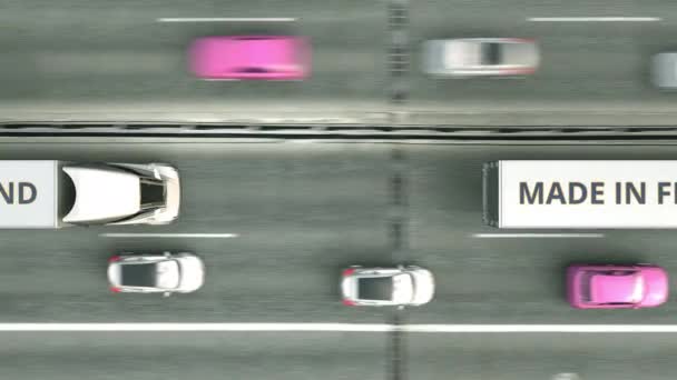 Vista aérea de arriba hacia abajo de los camiones remolque con texto MADE IN FINLAND conduciendo a lo largo de la carretera. Animación 3D loopable relacionada con el negocio finlandés — Vídeos de Stock