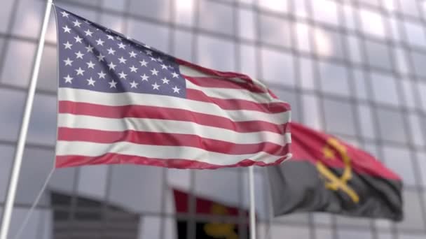 Waving flags of the United States and Angola in front of a modern skyscraper — Stock Video