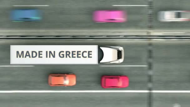 Aerial top down view of trailer trucks with MADE IN GREECE text driving along the road. Greek business related loopable 3D animation — Stock Video