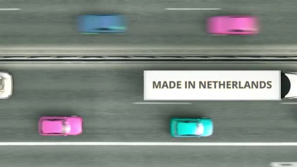 Caminhões de reboque com texto MADE IN PAÍSES BAIXOS dirigindo ao longo da estrada. Animação 3D loopable relacionada com negócios holandeses — Vídeo de Stock