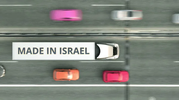 Εναέρια πάνω προς τα κάτω άποψη του ημι-ρυμουλκούμενο φορτηγό με Made In Israel κείμενο οδήγηση κατά μήκος του δρόμου. Ισραηλινή επιχείρηση 3d απόδοση — Φωτογραφία Αρχείου