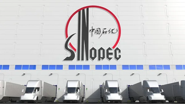 Camiones semirremolques eléctricos en la bahía de carga del almacén con el logotipo de SINOPEC en la pared. Representación Editorial 3D —  Fotos de Stock