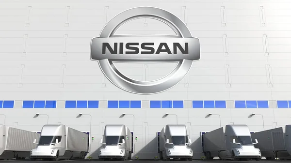 Electric semi-trailer trucks at warehouse loading bay with NISSAN logo on the wall. Editorial 3D rendering — Stock Photo, Image