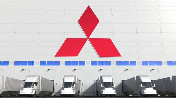 Modernos camiones semirremolques en la bahía de carga del almacén con el logotipo de MITSUBISHI en la pared. Representación Editorial 3D —  Fotos de Stock
