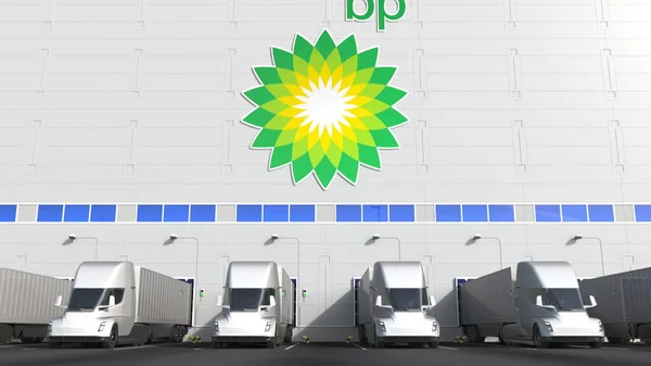 Elektrische Sattelschlepper auf der Ladefläche einer Lagerhalle mit BP-Logo an der Wand. Editorisches 3D-Rendering — Stockfoto