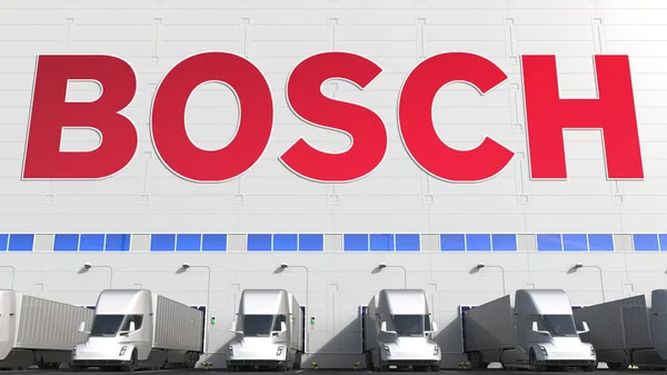 Camiones semirremolques eléctricos en la bodega de carga con el logotipo de BOSCH en la pared. Representación Editorial 3D —  Fotos de Stock