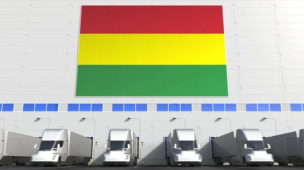 Trucks at warehouse loading bay with flag of BOLIVIA. Bolivian logistics related conceptual 3D rendering — Stock Photo, Image