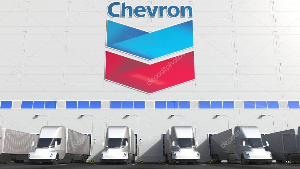 Trailer trucks at warehouse loading bay with logo on the wall. Editorial 3D