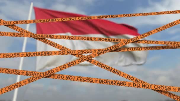 Do not cross biohazard tape lines on the Indonesian flag background. Restricted entry or quarantine in Indonesia. Conceptual looping 3D animation — Stock Video