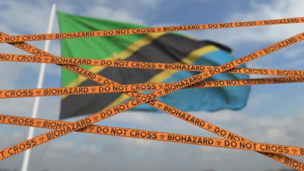 Biohazard Restriction Tapes gegen die tansanische Flagge. Beschränkter Grenzübertritt oder Quarantäne in Tansania. Konzeptionelle 3D-Animation in Schleifen — Stockvideo