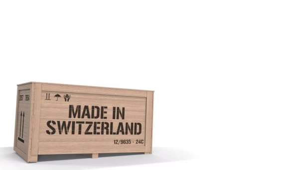 Trälåda med MADE IN SWITZERLAND text på vit bakgrund. Schweizisk industriell produktionsrelaterad 3D-animering — Stockvideo