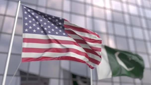 Waving flags of the USA and Pakistan near modern skyscraper — Stock Video