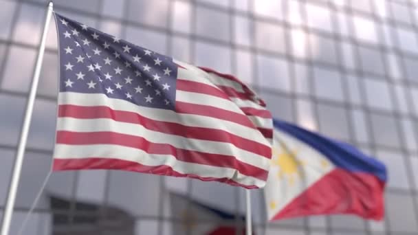 Viftande flaggor från USA och Filippinerna framför en modern skyskrapa — Stockvideo