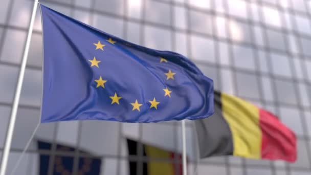 Waving flags of the EU and Belgium in front of a modern skyscraper — Stock Video