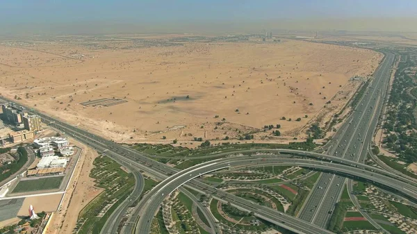 Вид с воздуха на большую дорожную развязку и пустыню вблизи Дубая, ОАЭ — стоковое фото