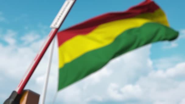 Cerrando la barrera del boom con el letrero QUARANTINE contra la bandera boliviana. Cierre de fronteras o aislamiento relacionado con infecciones en Bolivia — Vídeo de stock