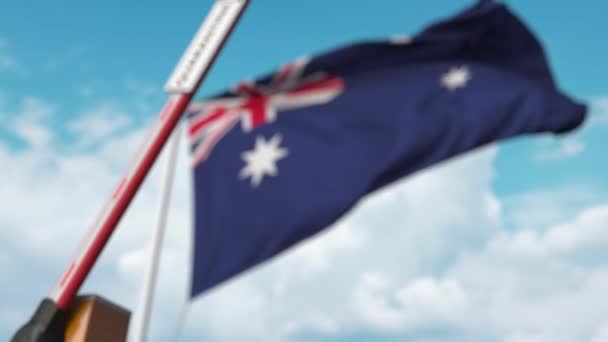 Zamknięta brama boom ze znakiem kwarantanny na tle australijskiej flagi. Zamknięcie granicy lub izolacja związana z zakażeniem w Australii — Wideo stockowe