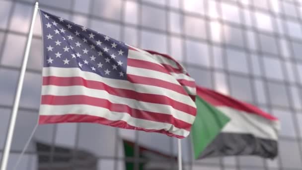 Machające flagi USA i Sudanu przed nowoczesnym drapaczem chmur — Wideo stockowe