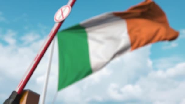 Puerta de pluma cerrada con señal de STOP CORONAVIRUS en el fondo de la bandera irlandesa. Cuarentena en Irlanda — Vídeo de stock
